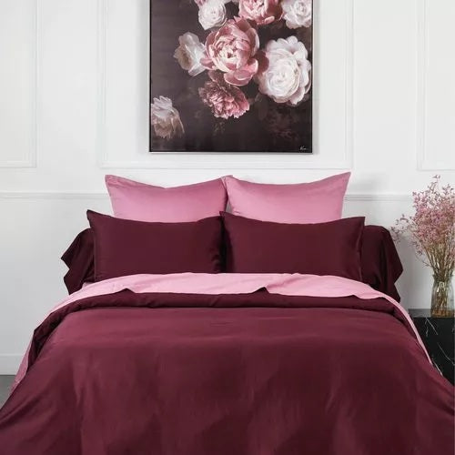 Parure de lit bordeaux et rose dans une chambre élégante