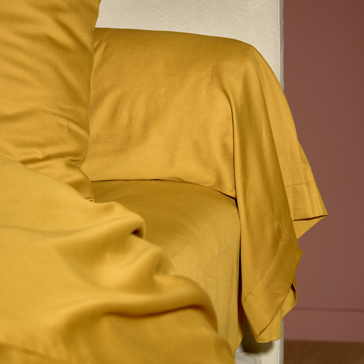 zoom sur le drap housse et la taie de traversin coloris ocre #Couleur_OCRE