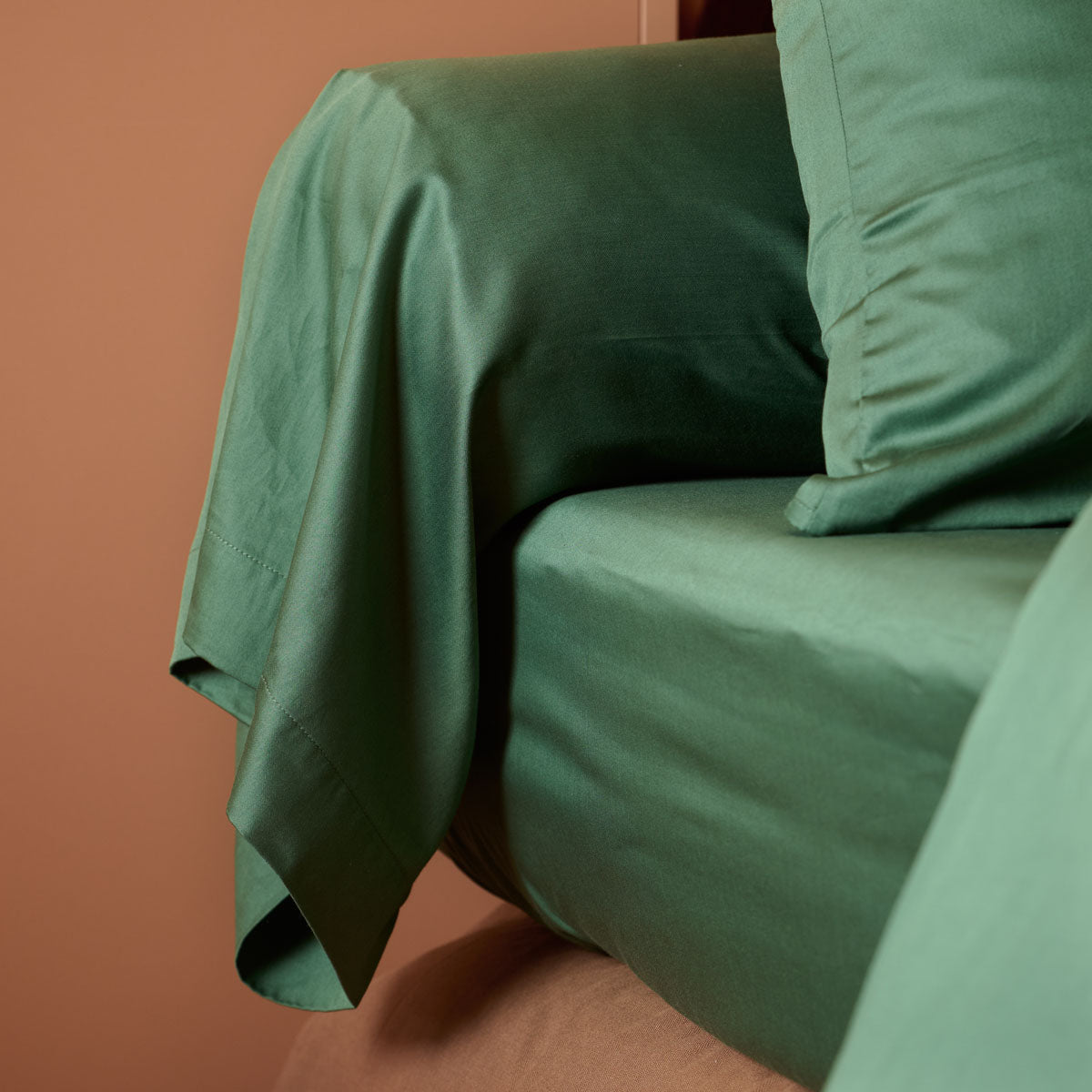 zoom sur le drap housse et la taie de traversin coloris vert sapin #Couleur_VERT PROFOND