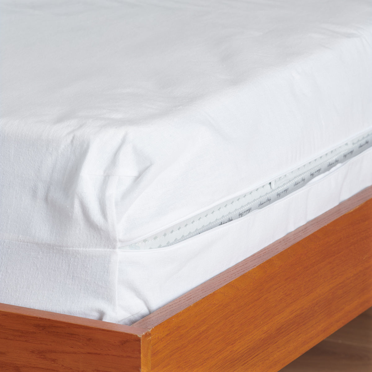Ouverture zippée de la housse intégrale Céline pour une protection complète du matelas.