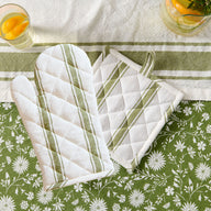 manique verte et gant de cuisine sur nappe fleurie #Couleur_VERT