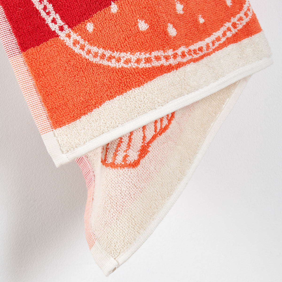 Zoom sur l’éponge jacquard en coton épais. Coloris rouge 
Essuie-main Confiture avec motif fruit.