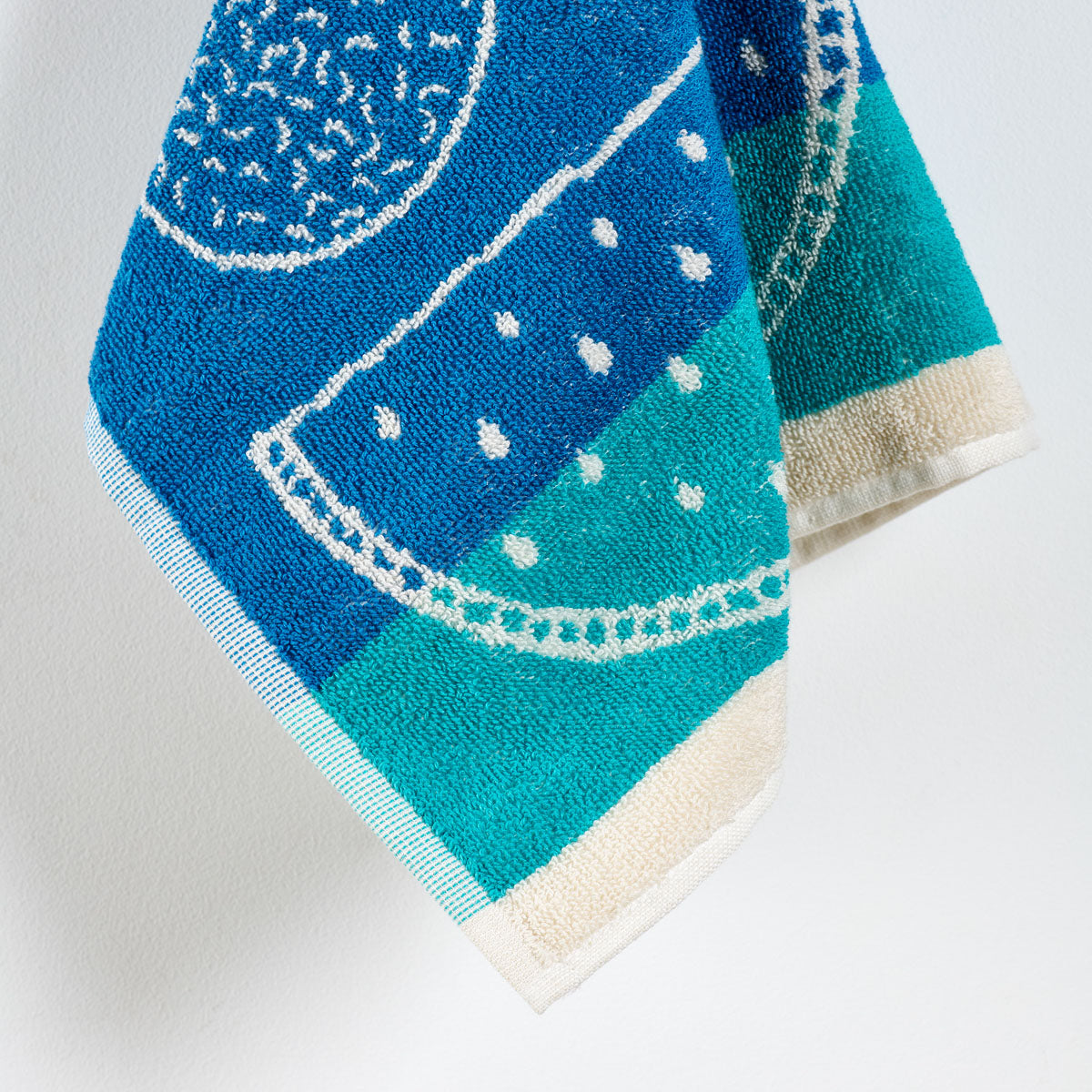 Zoom sur l’éponge jacquard en coton épais. Coloris bleu 
Essuie-main Confiture avec motif fruit.