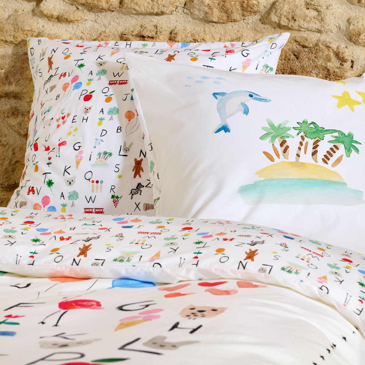 Zoom sur les taies carrées réversibles de la parure de lit enfant Abécédaire.