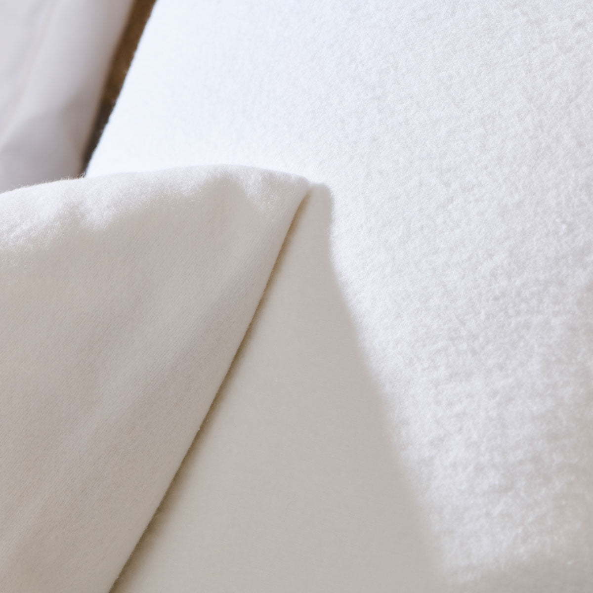 Zoom sur le moelleux du protège oreiller luxe