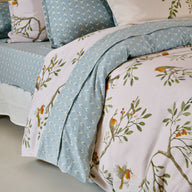Drap plat Doux Refuge en flanelle de coton 160 g/m², imprimé oiseaux et feuillages, avec parement floral vert céladon de 20 cm.