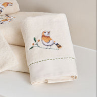 Serviette de toilette Doux Refuge 50 × 100 cm coloris Lin, en éponge de coton brodée, présentée dans une salle de bain.