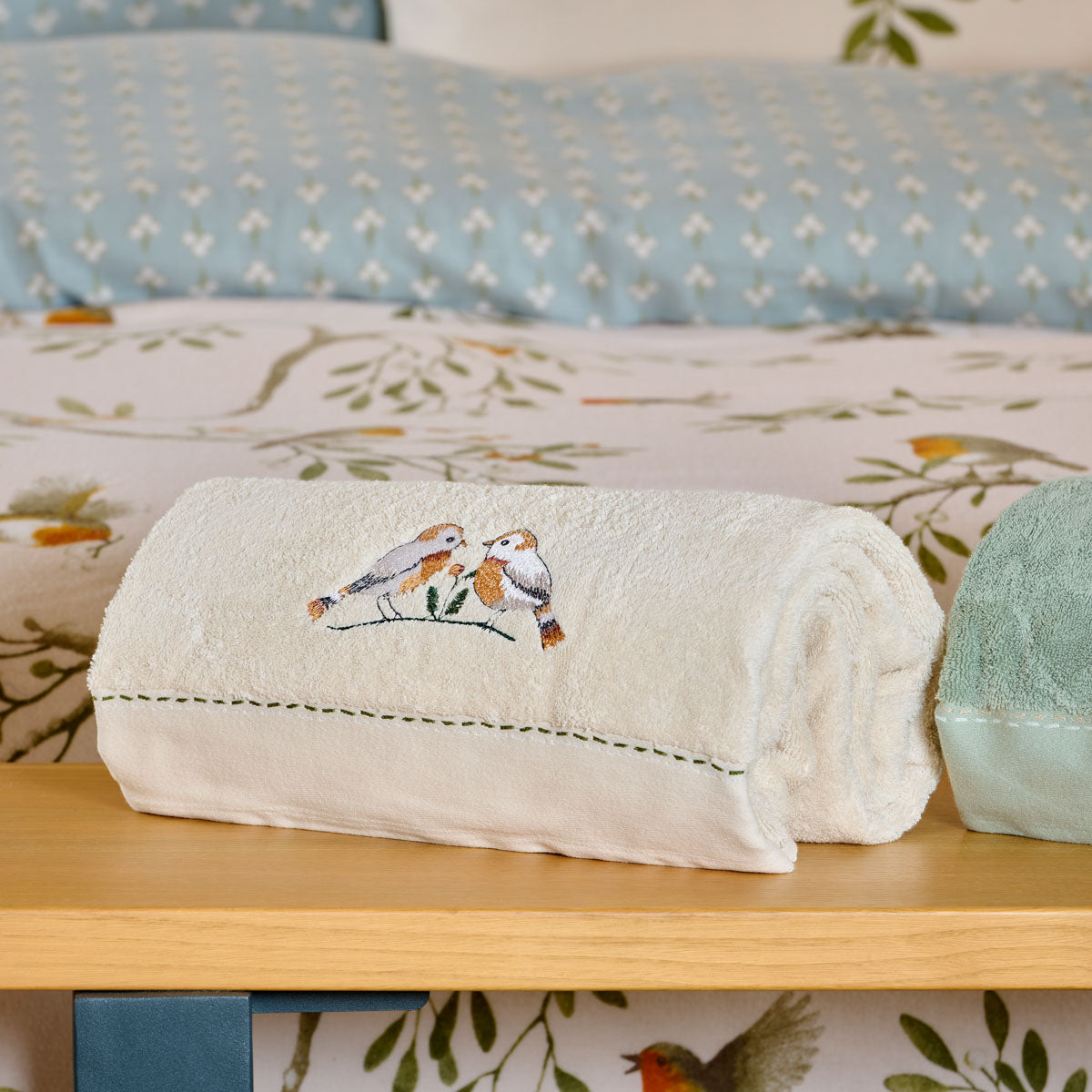 Drap de bain brodé Doux Refuge associé à la parure de lit aux motifs d'oiseaux