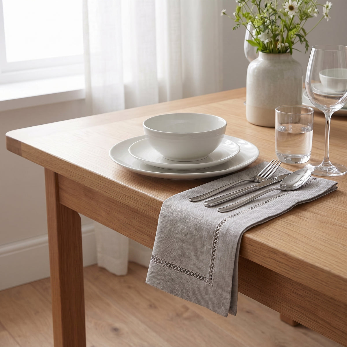 Serviettes de table Florence 45 × 45 cm avec finition ajourée, présentées sur une table en bois.