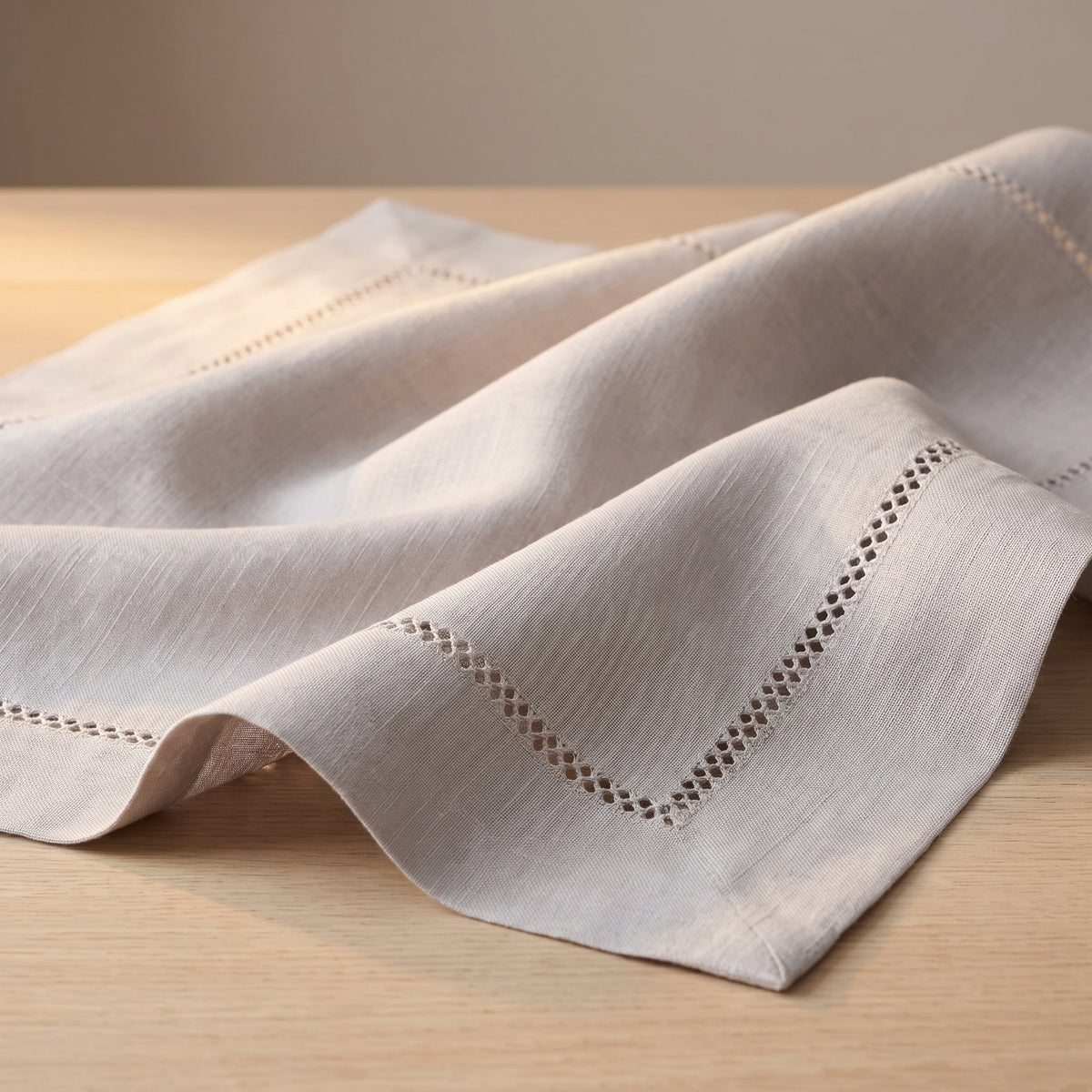 Détail de la finition ajourée du linge de table Florence en polyester texturé.